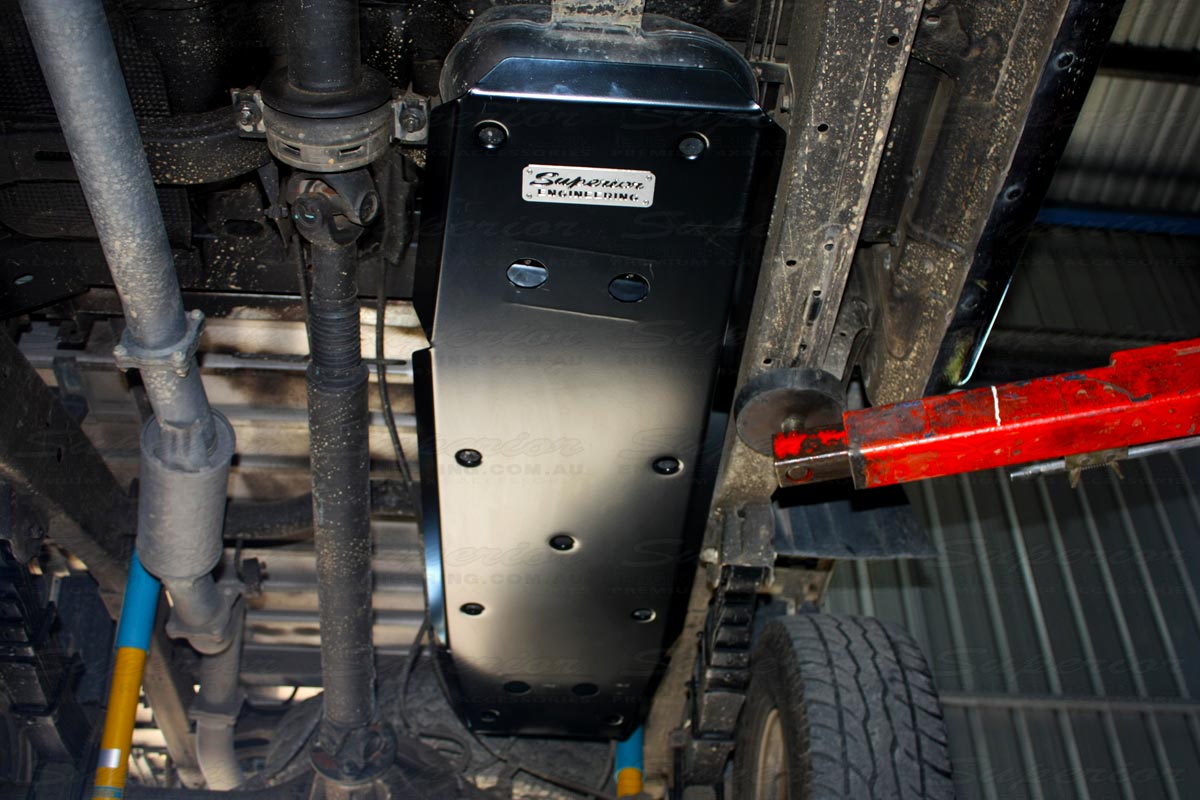 A closeup under vehicle view of the Superior Engineering aftermarket fuel tank guard which has been fitted to the Ford Ranger which fully covers the fuel tank and perfectly integrates into the vehicle design